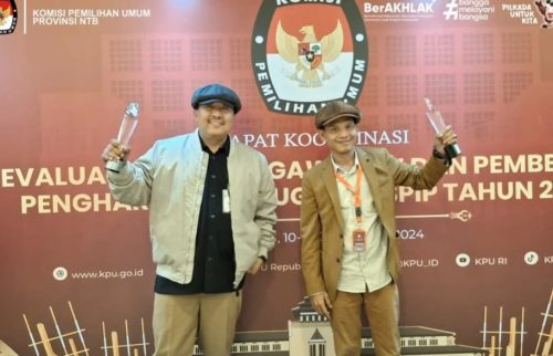 Sekretaris dan Komisioner KPUD NTB Mastur saat menerima penghargaan dari KPU RI. (Iba/Ist)