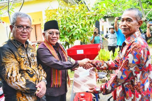 Bupati KLU Nazmul Akhyar didampingi Plt Direktur Bank NTB Syariah menyerahkan bantuan alat pertanian kepada warga. (Iba/ADV)