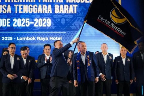 Ketua DPW Partai NasDem NTB Mori Hanafi mengibarkan bendera pusaka NasDem saat dilantik di Hotel Lombok Raya bersama jajaran pengurus, Sabtu 12 Juli 2025. (Iba)