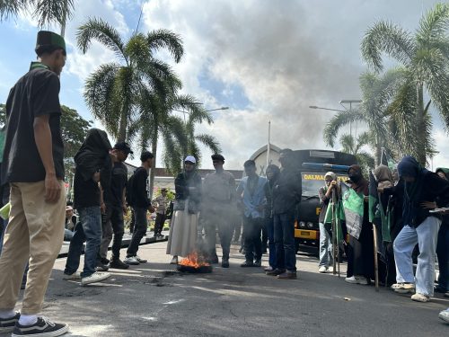Puluhan massa aksi dari HMI MPO Cabang Mataram membakar ban bekas di halaman kantor Gubernur NTB, Jumat 17 April 2026 di Mataram. (Iba)