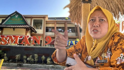 Kepala SMA Negeri 9 Mataram Nengah Istiqomah berlatar gedung sekolahnya. (Iba)