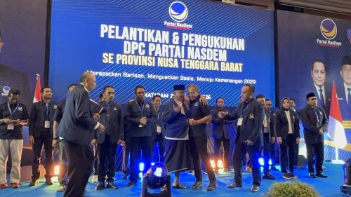 Saan Mustopa memakaikan jas Nasdem kepada pimpinan yayasan Al-Hidayah TGH Rahmat Hidayat didampingi Ketua DPW NasDem NTB Mori Hanafi. (Iba)